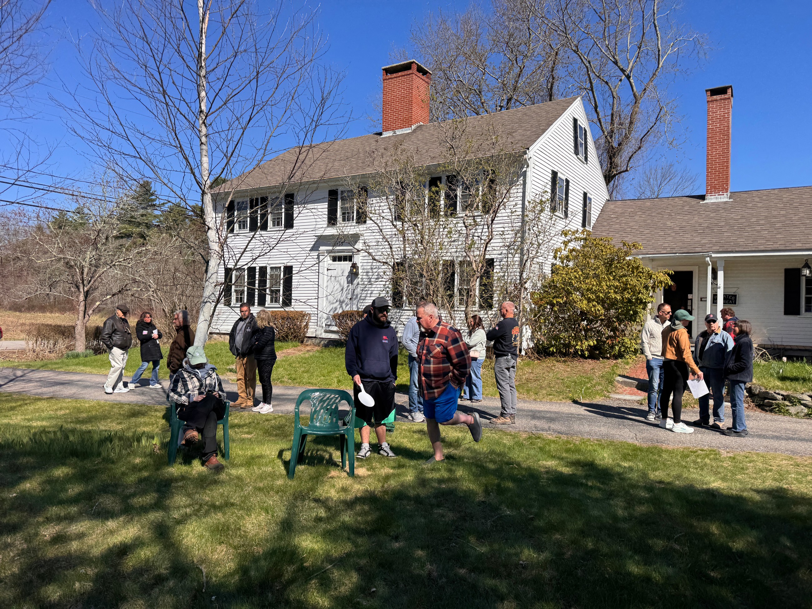 People gathering outside of a house for an auction